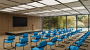 Lightweight Nautilus Designs Aria stackable boardroom chair with blue fabric upholstery and modern ergonomic design.
