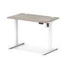 Dynamic Air Lite height adjustable slimline desk in grey oak with cable ports and modern design.