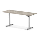 Dynamic Air Lite height adjustable slimline desk in grey oak with cable ports, featuring a modern design and adjustable height functionality.