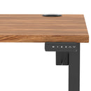 Dynamic Air Lite height adjustable desk with walnut finish and cable ports, featuring sleek design and ergonomic workspace.