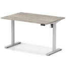 Dynamic Air Lite height adjustable desk in grey oak finish with cable ports, featuring modern design and ergonomic functionality.