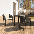 ZAP Portofino stacking armchair with woven seat and backrest, shown in a modern indoor setting with wooden flooring.