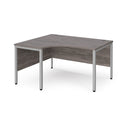 Dams Maestro 25 ergonomic desk with bench legs in grey oak finish, featuring a spacious work surface and modern design.