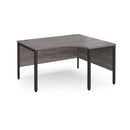 Dams Maestro 25 ergonomic desk with bench leg in grey oak finish, showcasing a modern office workspace with a spacious surface.