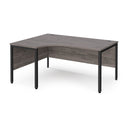 Dams Maestro 25 ergonomic desk with bench leg in grey oak finish, showcasing modern office workspace with spacious surface.