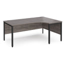 Dams Maestro 25 ergonomic desk with bench leg in grey oak finish, showing the spacious surface and modern design.