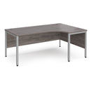 Dams Maestro 25 ergonomic desk with bench leg in grey oak finish, featuring a spacious work surface and modern design.