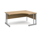 Dams Momento ergonomic oak desk with cantilever leg, shown from the left side with a spacious workspace and modern design.