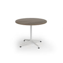 Dams Loft Circular Dining Table in Nebraska Oak finish with a smooth, round tabletop and sturdy wooden legs.
