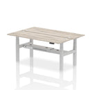 Dynamic Air 2-person back-to-back slimline height adjustable desk bench in grey oak, showing its modern design and adjustable features.