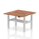 Dynamic Air 2-person back-to-back slimline height adjustable desk bench in walnut wood with metal frame, ideal for office or workspace.