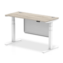 Grey oak Air 600mm deep height adjustable desk by Dynamic with cable ports and steel modesty panel, shown from front view.
