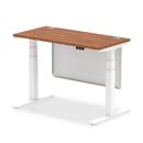 Dynamic Air 600mm deep height adjustable desk in walnut with cable ports and steel modesty panel, showing a modern workspace setup.