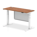 Dynamic Air 600mm deep height adjustable desk in walnut with cable ports and steel modesty panel, shown from side view.