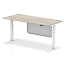 Dynamic Air 800mm deep height adjustable desk in grey oak with cable ports and steel modesty panel, shown from a side angle.