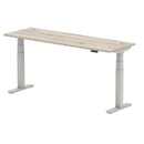 Dynamic Air Slimline height adjustable desk in grey oak with cable ports, showcasing a modern office workspace setup.