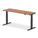 Dynamic Air Slimline height adjustable desk in walnut finish with cable ports, showcasing its sleek design and modern workspace setup.
