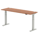 Dynamic Air Slimline height-adjustable desk in walnut finish with cable ports, featuring a modern design and sleek workspace setup.