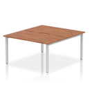 Dynamic Evolve Plus B2B 2-person bench desk in walnut wood finish, featuring a sleek silver frame and modern design.