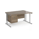 Dams Maestro 25 Wave desk with Nebraska Oak finish, cantilever legs, and fixed 2-drawer pedestal, shown from side view.