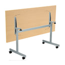 Back view of the One Eighty rectangular tilting table in Nova Oak finish by TC, showing the adjustable tilting mechanism and wood grain texture.