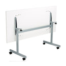 White One Eighty Rectangular Tilting Table by TC with adjustable tilt and sturdy metal frame, shown from the back angle.