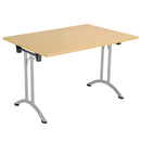Rectangular folding table with Nova Oak finish by TC, featuring a sturdy design and compact foldable form for versatile use.