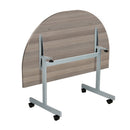 Back view of the One Eighty D-End Tilting Table in grey oak by TC, showcasing its sleek design and tilting feature.