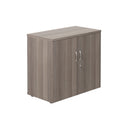Front view of TC Essentials Wooden Cupboard in grey oak finish, showcasing its sleek design and storage compartments.