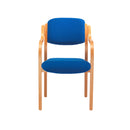Front view of TC Renoir armchair with wooden legs and upholstered seat in a modern living room setting.