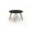 Black Unity circular dining table with solid oak legs by Dams, showcasing a sleek, modern design and sturdy construction.