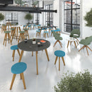 Unity circular dining table by Dams with black finish and solid oak legs, shown in a modern dining room setting.