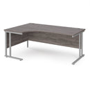 Dams Maestro 25 ergonomic desk with grey oak finish and cantilever leg, shown from the left side with silver metal supports.